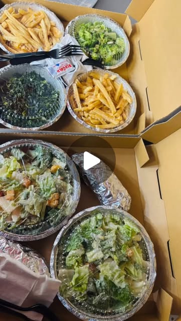 Catering spread — fries, broccoli, salads, caesar bowls